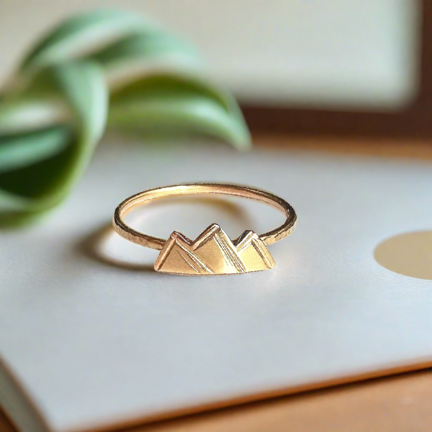 small gold mountain ring with 3 small peaks on a dainty gold textured band