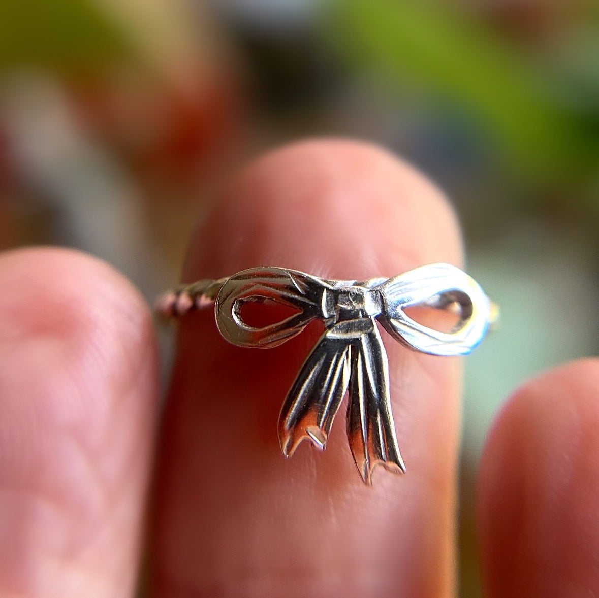 silver bow ring on finger
