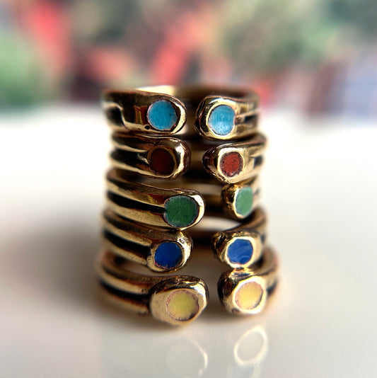 enamel rings sentinel ring by Julie Godsey jewelry a stack of rings with the enamel colors of light blue, red, green, dark blue, and yellow to represent the elements of nature for strength and protection