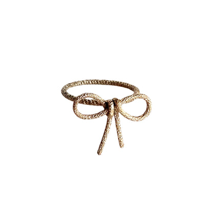 Gold bow ring textured metal ring in shape of a ribbon or knot or tie 