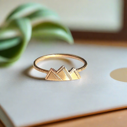 small gold mountain ring with 3 small peaks on a dainty gold textured band 