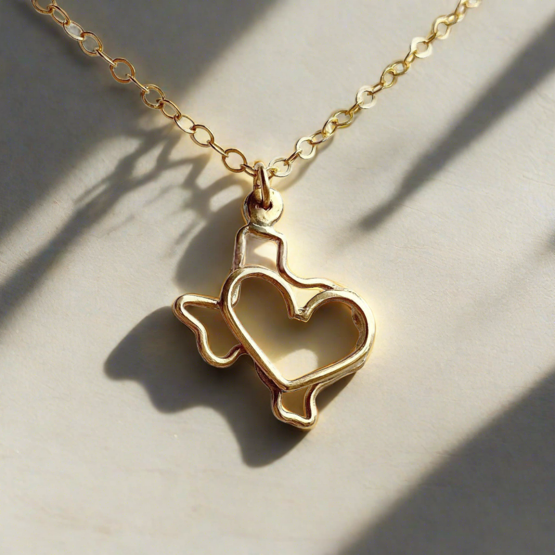 gold texas outline necklace with heart in the middle on a sunny surface generated by AI