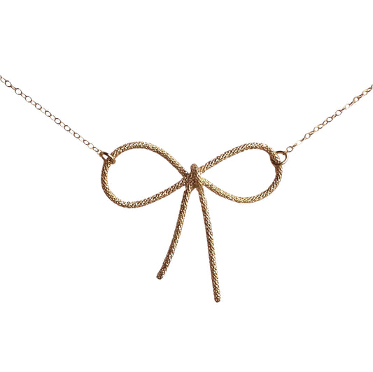 gold sparkle wire bow pendant necklace wire tied into a bow 2 inches across with dainty gold chain connecting onto each loop of the ribbon/bow