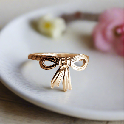 gold bow ring with coquette core vibe and background 