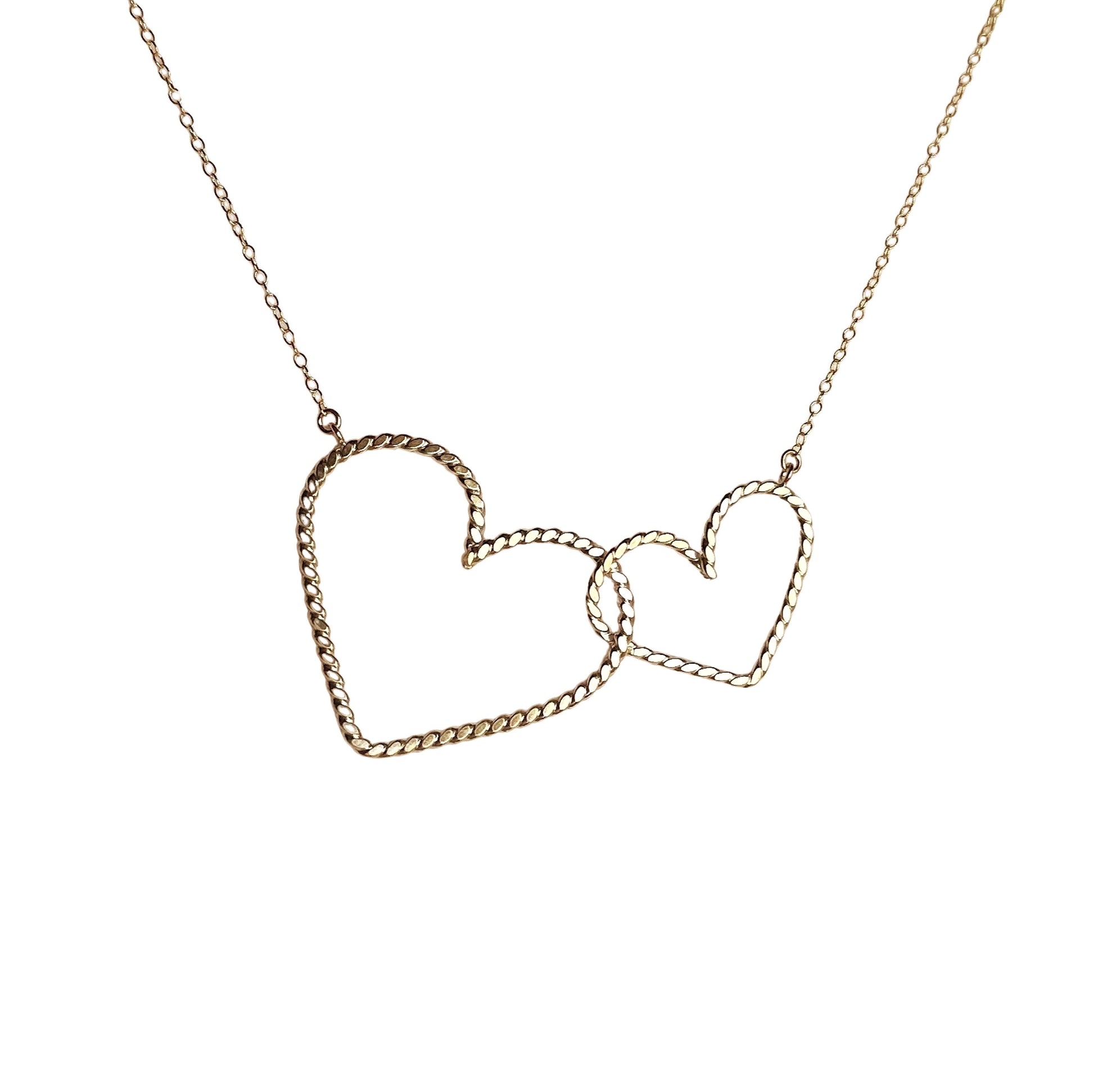 gold interlocking heart necklace, 2 hearts one big one smaller interlocked and hanging from a delicate gold chain